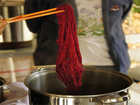 Red yarn dyed with cochineal lifted out of dye pot