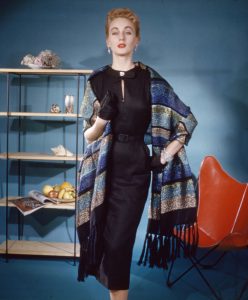Model wearing a wool and Lurex stole made by Churchill Weavers, 1950s