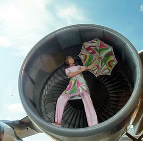 Image 2 (above). Braniff hostess wearing a floral Pucci uniform and umbrella standing in the front part of a jet engine. Braniff Airways Collection, History of Aviation Collection, Eugene McDermott Library, The University of Texas at Dallas.