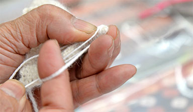 Closeup of hands working with yarn