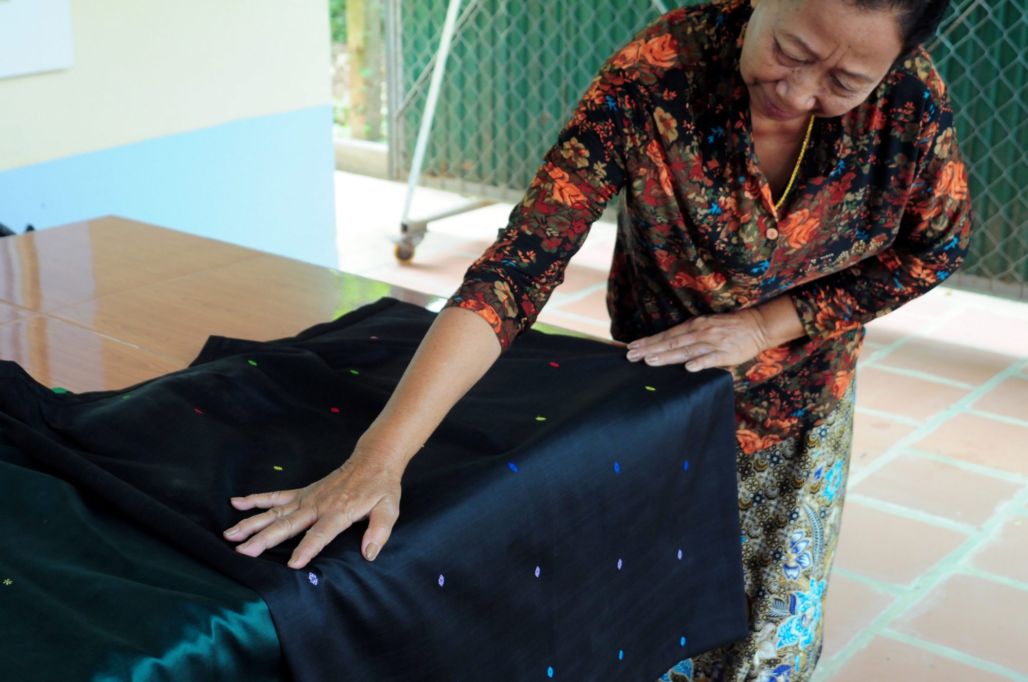 former weaver, showing a black silk phamuong