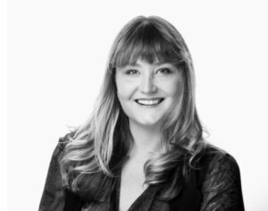 black and white photo of the torso of a white woman, smiling
